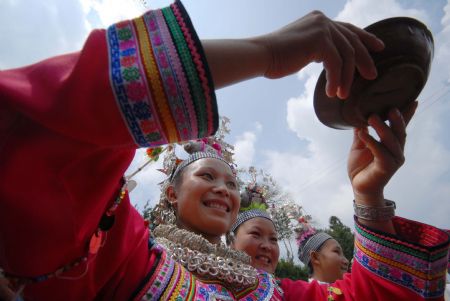 A girl sings a song when serving wine to the guest at the Chixin Festival, or New Grain Tasting Festival, in a village of the Miao ethnic group in Duyu City of southwest China's Guizhou Province, Aug. 28, 2009. (Xinhua/Qiao Qiming) 