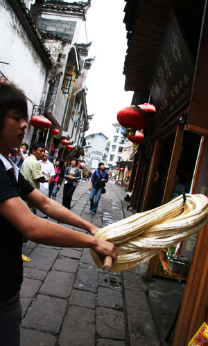 A vendor displays how 'twisted ginger sugar' is made. [Photo: CRIENGLISH.com/Duan Xuelian] 