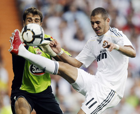 Real Madrid's Karim Benzema (R) controls the ball in front of Deportivo Coruna's goalkeeper Daniel Aranzubia during their Spanish first division soccer match at Santiago Bernabeu stadium in Madrid August 29, 2009.(Xinhua/Reuters Photo)