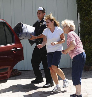 A Glendale Police officer helps residents evacuate from the La Canada Flintridge area of Los Angeles, California during the Station Fire August 29 ,2009. 