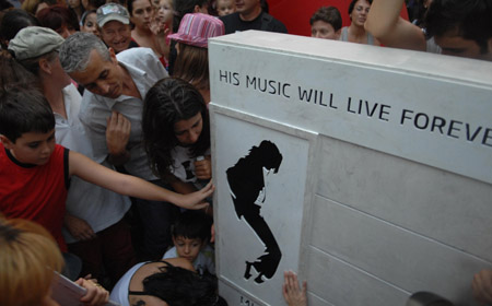 Romanian Michael Jackson fans crowd to touch a memorial for the artist which was inaugurated in the Herastrau park in Bucharest, Romania, Saturday, Aug. 29, 2009. Hundreds of fans attended the event, in which one of the park's main alleys was named the Michael Jackson Alley on what would have been the late pop star's 51st birthday.