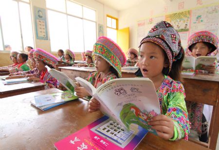 Girl students of a Hope School read their new school books in Longlin county, southwest China's Guangxi Zhuang Autonomous Region, August 31, 2009. Some 57,000 poor students in rural areas in Longlin county would receive free textbooks. (Xinhua/Lin Bin)