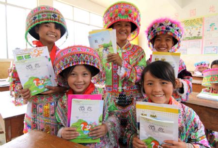 Minority girl students of a Hope School show their free new school books in Longlin county, southwest China's Guangxi Zhuang Autonomous Region, August 31, 2009.(Xinhua/Lin Bin)
