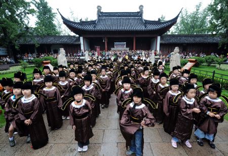 Pupils in traditional costumes attend a ceremony in a Confucius temple in Nanjing,east China's Jiangsu province, August 31, 2009. New school starters from a primary school took part in the ceremony marking the beginning of their studying age.(Xinhua/Sun Can) 