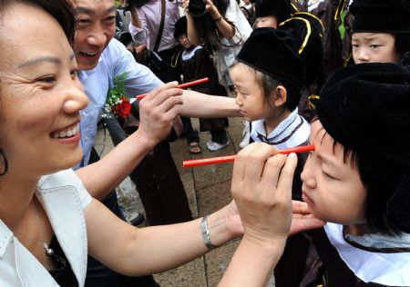 Teachers dot pupils' glabellas with cinnabar during a ceremony in a Confucius temple in Nanjing, east China's Jiangsu province, August 31, 2009. (Xinhua/Sun Can)