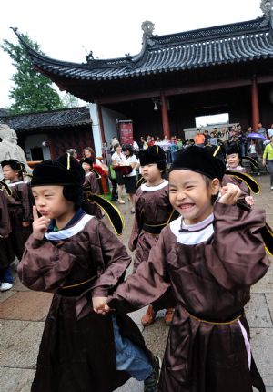  Pupils in traditional costumes come to attend a ceremony in a Confucius temple in Nanjing, east China's Jiangsu province, August 31, 2009. (Xinhua/Sun Can)