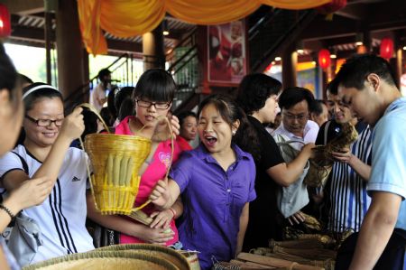 Tourists choose works of handicraft at a special local products fair during the Nv'erhui Festival in Enshi autonomous prefecture of the Tujia and Miao ethnic groups in central China's Hubei Province, Aug. 31, 2009.(Xinhua/Hao Tongqian) 