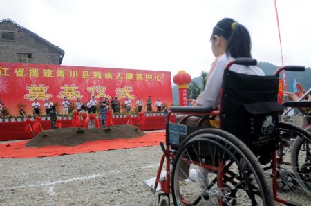 A handicapped girl in wheelchair attends the cornerstone-laying ceremony of a rehabilitation center in the May 12, 2008 earthquake-striken Qingchuan county, southwest China's Sichuan province, August 30, 2009. The centre is donated by the government and people of east China's Zhejiang Province. (Xinhua/Song Jianhao)