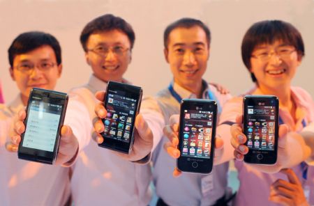 Employees of China Mobile show off different designs of OPhone handsets at the first-issuing ceremony in Beijing, China, August 31, 2009. China Mobile launched Monday its independently developed OPhone operating system, together with the designs of OPhone handsets, to meet competitions from China Telecom and China Unicom, the two other major telecommunications companies in China. (Xinhua/Yuan Zhou)