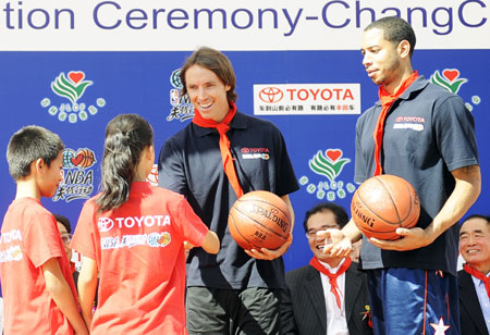 NBA players Steve Nash(2nd R) and Devin Harris (1st R) donate basketballs to students of a primary school of rural migrant workers' children during the NBA Cares Program in Changchun, capital of northeast China's Jilin Province, Aug. 31, 2009. (Xinhua/Wang Haofei)