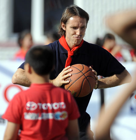 NBA player Steve Nash(R) directs the ball-passing techniques to students in a primary school for rural migrant workers' children during the NBA Cares Program in Changchun, capital of northeast China's Jilin Province, Aug. 31, 2009.(Xinhua/Wang Haofei)