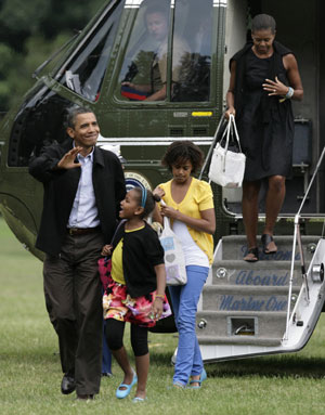 U.S. President Barack Obama waves as he walks with first lady Michelle Obama and their daughters Sasha (2nd L) and Malia and on the South Lawn of the White House in Washington August 30, 2009. The first family returned to Washington after a week-long vacation in Martha's Vineyard in Massachusetts.