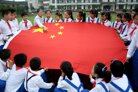 A Chinese primary school teacher explains to her students about information of the Chinese national flag at a ceremony marking the first day of the new semester in the city of Hanshan in east China's Anhui Province, Sep. 1, 2009. School students across China started Tuesday their new semester. (Xinhua/Cheng Qianjun)