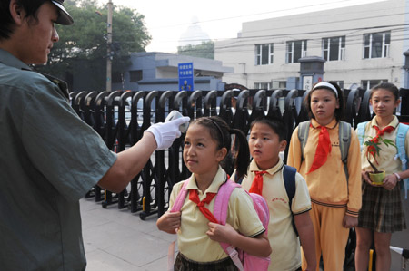 Students of Beijing No. 2 Experiment Primary School queue for temprerature check at the school gate in Beijing, China, on Sep. 1, 2009. (Xinhua/Li Qingshan)