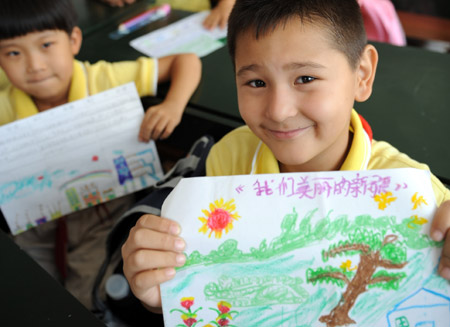 Students from the 3rd Grade of Urumqi No. 10 Primary School display their drawings named 'My Beautiful Xinjiang' on the first day of the new semester in Urumqi, capital of northwest China