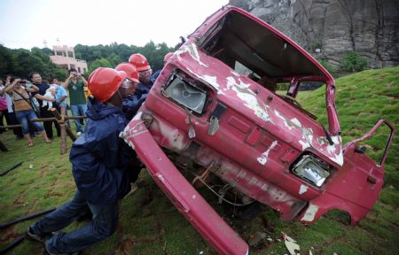 Tourists try to smash a scrapped pickup during a pressure releasing activity held in a park in Changsha, capital of central China's Hunan Province, Sep. 1, 2009. (Xinhua/Li Ga) 