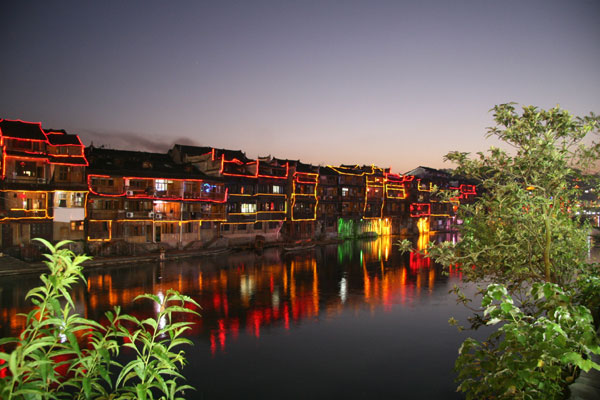 Phoenix shows her glamour when the night falls. The sparkling neon lights lining the stilted houses serve as her makeup. [Photo:CRIENGLISH.com/Duan Xuelian] 