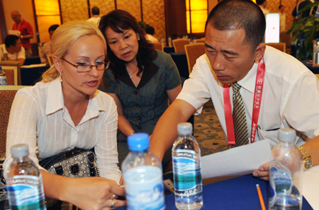 Merchants at home and abroad discuss during the 18th Urumqi Trade Fair in Urumqi, capital of northwest China's Xinjiang Uygur Autonomous Region, Sept. 1, 2009. 