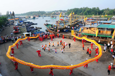 Local fishermen perform dragon dance during a sacrifice ceremony in Tanmen Harbor in Qionghai City of south China's Hainan Province, Sep. 1, 2009. (Xinhua/Meng Zhongde)
