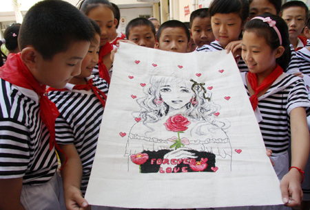  Pupils gather to appreciate a cross-stitch pattern elaborately wrought by one of their classmate in the summer vacation, as pupils enthusiastically present their versatile talents and skills in hand-making, painting, calligraphy, etc, which they learned and improved as a result of less home works and more social practices during the summer holidays, in the very first day of the new semester, at the Junshan Road Elementary School, in Zaozhuang, east China's Shandong Province, Sept. 1, 2009. (Xinhua/Sun Zhongzhe) 