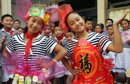  Pupils hold high their respective works of talent finished during the summer vacation for a collective presentation, as they enthusiastically present their versatile talents and skills in hand-making, painting, calligraphy, etc, which they learned and improved as a result of less home works and more social practices during the summer holidays, in the very first day of the new semester, at the Junshan Road Elementary School, in Zaozhuang, east China's Shandong Province, Sept. 1, 2009. (Xinhua/Sun Zhongzhe) 