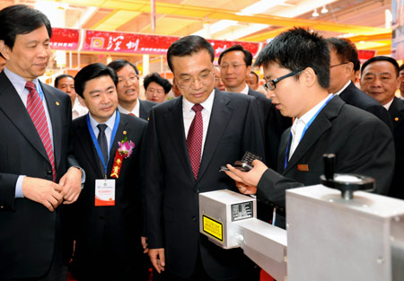 Chinese Vice Premier Li Keqiang (2nd R, front) visits the exhibit venue after the opening ceremony of the Northeast Asia Investment and Trade Expo held in Changchun, capital of northeast China's Jilin Province, Sept. 1, 2009.(