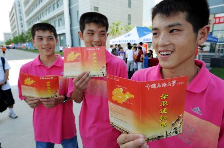 Triplet brothers Zhao Lingxiao, Zhao Linghan and Zhao Lingyun display their letters of admission of China University of Petroleum (Huadong) in Qingdao, east China's Shandong Province, Sept. 2, 2009. The triplets from Xiaoheya Village of Gaomi City in Shandong got high marks in the college entry examination this year. (Xinhua/Li Ziheng)