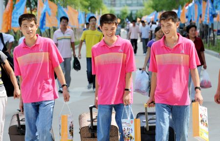 Triplet brothers Zhao Lingxiao, Zhao Linghan and Zhao Lingyun walk on the campus of China University of Petroleum (Huadong) in Qingdao, east China's Shandong Province, Sept. 2, 2009.(Xinhua/Li Ziheng) 