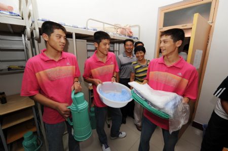 Triplet brothers Zhao Lingxiao, Zhao Linghan and Zhao Lingyun talk at the dormitory at the China University of Petroleum (Huadong) in Qingdao, east China's Shandong Province, Sept. 2, 2009.(Xinhua 