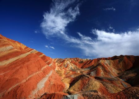The file picture taken on July 26, 2009 shows the unique hilly terrain with red rocks and cliffs of the Danxia Landform in the mountainous areas of the Zhangye Geology Park near the city of Zhangye in northwest China's Gansu Province.(Xinhua/Fu Chunrong) 