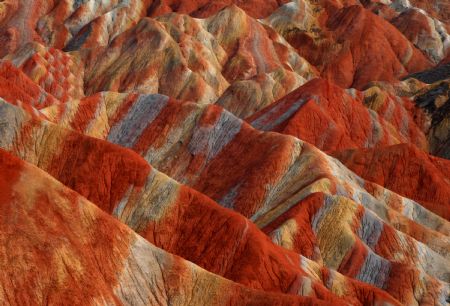 The file picture taken on July 26, 2009 shows the unique hilly terrain with red rocks and cliffs of the Danxia Landform in the mountainous areas of the Zhangye Geology Park near the city of Zhangye in northwest China's Gansu Province. Danxia Landform belongs to red terrestrial clastic rock landform, which is characterized by its red cliffed scarp. (Xinhua/Fu Chunrong)