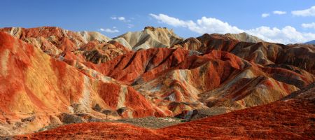 The file picture taken on July 26, 2009 shows the unique hilly terrain with red rocks and cliffs of the Danxia Landform in the mountainous areas of the Zhangye Geology Park near the city of Zhangye in northwest China's Gansu Province.(Xinhua/Fu Chunrong