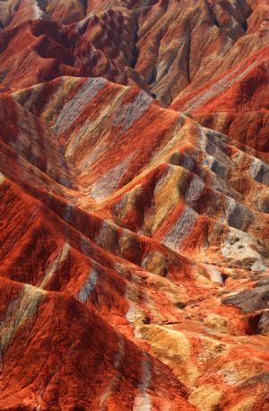 The file picture taken on July 26, 2009 shows the unique hilly terrain with red rocks and cliffs of the Danxia Landform in the mountainous areas of the Zhangye Geology Park near the city of Zhangye in northwest China's Gansu Province.(Xinhua/Fu Chunrong
