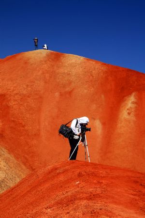 The file picture taken on July 26, 2009 shows the unique hilly terrain with red rocks and cliffs of the Danxia Landform in the mountainous areas of the Zhangye Geology Park near the city of Zhangye in northwest China's Gansu Province.(Xinhua/Fu Chunrong)