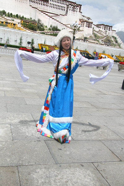 A local Tibetan woman is dancing in front of the Potala Palace in Lhasa during the Shoton Festival, which falls on August 20th, 2009. [Photo: CRIENGLISH.com]