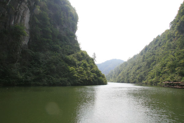 Tourists have to get on a bamboo raft and flow to the entrance of the stone cave before entering the village. [Photo:CRIENGLISH.com/Duan Xuelian]