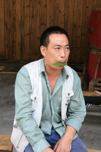 A villager plays a song with a tree leaf. [Photo:CRIENGLISH.com/Duan Xuelian]