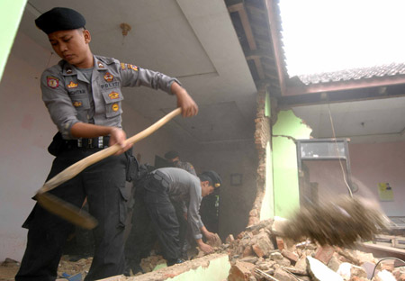 Police help quake victims to clear the destroyed houses in Tasik Malaya of West Java, Indonesia, Sept. 3, 2009. (Xinhua/Yue Yuewei)