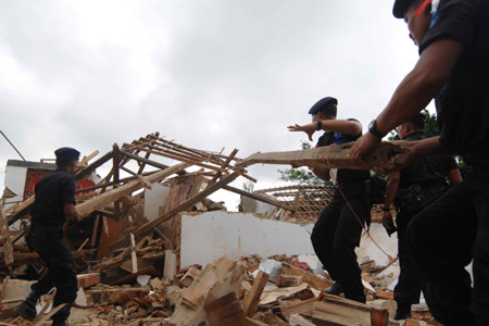 Police help quake victims to clear the destroyed houses in Tasik Malaya of West Java, Indonesia, Sept. 3, 2009. (Xinhua/Yue Yuewei)