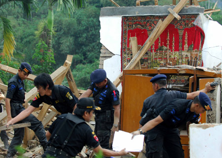 Police help quake victims to clear the destroyed houses in Tasik Malaya of West Java, Indonesia, Sept. 3, 2009. A 7.3-magnitude earthquake hit West Java on Wednesday, leaving some 44 people killed and more than 400 wounded. The Indonesian government has sent police to the quake-hit areas to help the victims. (Xinhua/Yue Yuewei)