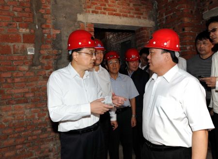 Chinese Vice Premier Li Keqiang (L) visits Bajiazi Forestry Bureau's shantytowns in Yanbian Korean Autonomous Prefecture, northeast China's Jilin Province, Aug. 31, 2009.