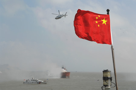 Chelicopter and rescue ships help control the fire and chemical leakage after a passenger ship collided with a cargo vessel during a maritime rescue exercise in the East China Sea, on Sept. 4, 2009. 