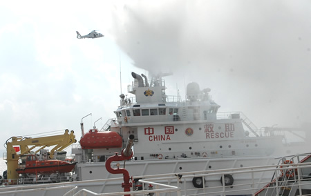 A rescue ship sprinkles water to control the fire on a passenger ship after a 'collision' during a maritime rescue exercise in the East China Sea, on Sept. 4, 2009. China's maritime rescue services staged their biggest ever exercise in the East China Sea Friday to test the country's maritime rescue capabilities and security for the Shanghai World Expo in 2010.