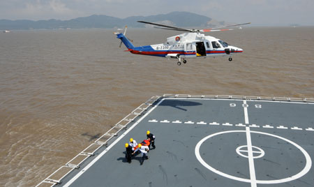 Medical workers rescue an 'injured' person transferred by a helicopter during a maritime rescue exercise in the East China Sea, on Sept. 4, 2009. China's maritime rescue services staged their biggest ever exercise in the East China Sea Friday to test the country's maritime rescue capabilities and security for the Shanghai World Expo in 2010. (Xinhua