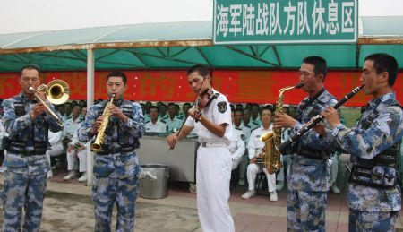 Soldiers play musical instruments during a break of an exercise for the military parade at an airport of People's Liberation Army in Beijing, capital of China, on Sept. 3, 2009. Soldiers are busy doing exercises to prepare for the scheduled military parade at the Tian'anmen square in Beijing to celebrate the 60th anniversary of founding of the People's Republic of China on Oct. 1. (Xinhua/Li Gang) 