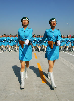 Photo taken on July 9, 2009 shows Zhang Xiaofei (L) and Zhao Na, both are 2009 graduating students of universities in Beijing, take part in the parade training as captains of female militia square in Beijing, capital of China. Participants are busy doing exercises to prepare for the scheduled military parade at the Tian'anmen square in Beijing to celebrate the 60th anniversary of the founding of the People's Republic of China on Oct. 1.[Zha Chunming/Xinhua]