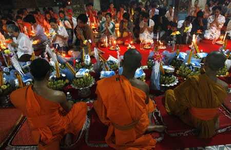 Cambodians pray in front of Buddhist monks at a temple on the first day of the 'Pchum Ben' festival, or Festival of the Dead, on the outskirts of Phnom Penh September 6, 2009. Cambodians visit temples during the 15-day festival to offer prayers to loved ones who have passed away.[Xinhua/Reuters] 