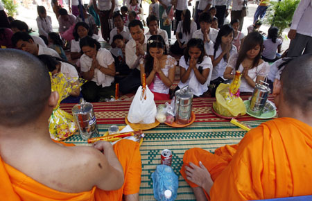 Cambodians pray in front of Buddhist monks at a temple on the first day of the 'Pchum Ben' festival, or Festival of the Dead, on the outskirts of Phnom Penh September 6, 2009. [Xinhua/Reuters]