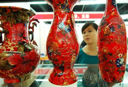 Visitors view artistic pottery and porcelain works in the international ceramic art expo in Zibo, one of the five major ceramic cities in east China's Shandong Province, Sept. 6, 2009.[Dong Naide/Xinhua]