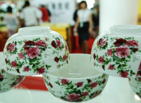 Visitors view artistic pottery and porcelain works in the international ceramic art expo in Zibo, one of the five major ceramic cities in east China's Shandong Province, Sept. 6, 2009.[Dong Naide/Xinhua]